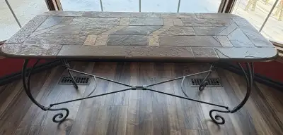 Slate top. Wrought iron base. Very heavy. Sold as set only. 1 sofa table, 1 coffee table, 1 end tabl...