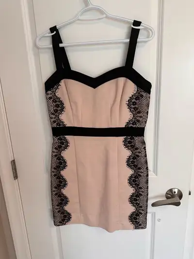 This is a Dynamite brand dress in a size medium. The dress is pink with black lace accents. It is in...