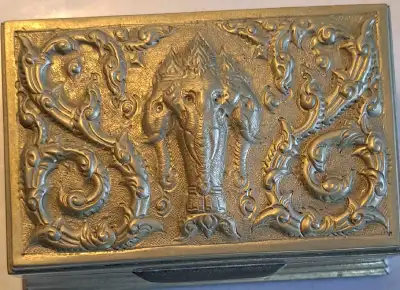 Intricate metal jewelry box has an embossed three-headed elephant design on the lid. This silver-ton...