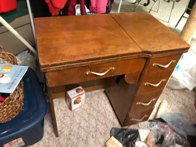 This is a vintage sewing machine cabinet, perfect for a sewing enthusiast looking for a project piec...