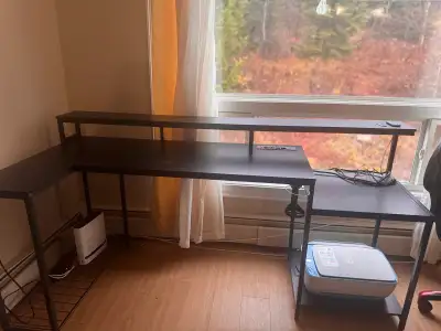 This used black desk features an L-shaped design with a top shelf, perfect for a home office or gami...