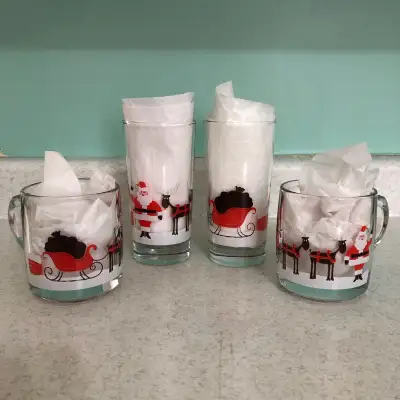 Set of vintage Christmas glassware, 2 mugs and 2 glasses. Santa and reindeer on a snow covered rooft...