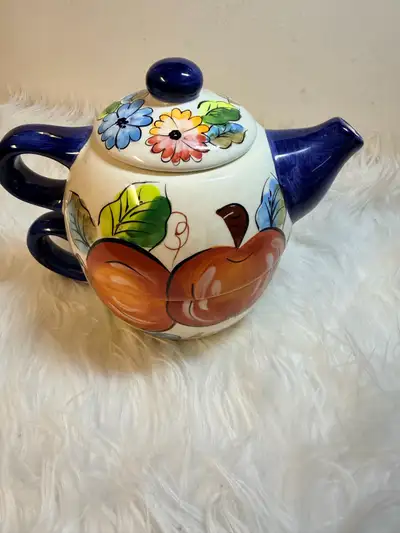 This charming ceramic teapot features a vibrant hand-painted design of colourful flowers and apples,...