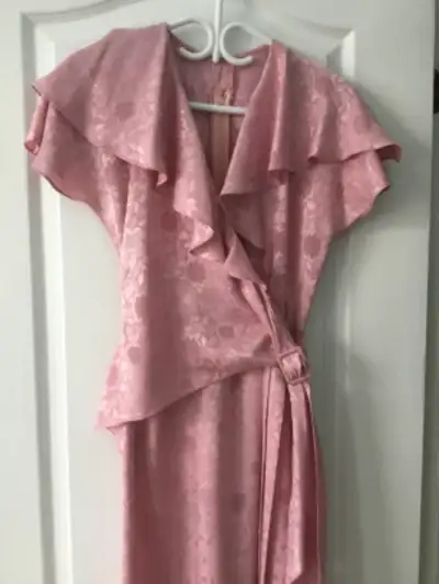 Superbe robe rose avec encolure à volants, aspect satiné à motif floral. En polyester, lavable à la...