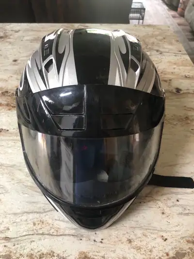 This Fuel motorcycle helmet features a sleek black and silver flame design, offering reliable protec...