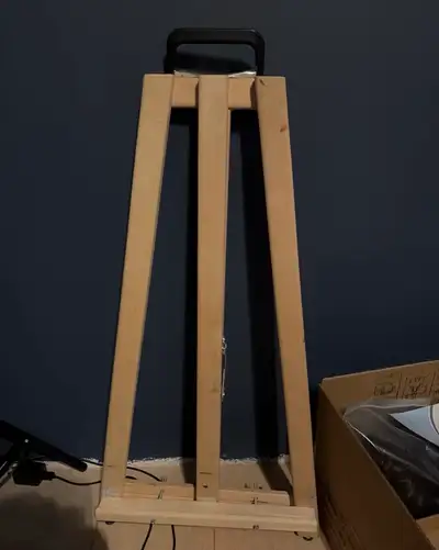 A sturdy wooden easel for artists. It's made of natural wood and features a portable design with a c...