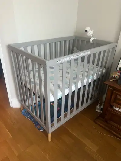 I am selling a mini crib in grey with a mattress. This compact crib is perfect for smaller spaces wh...