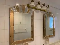 Two bathroom mirrors and a light fixture 