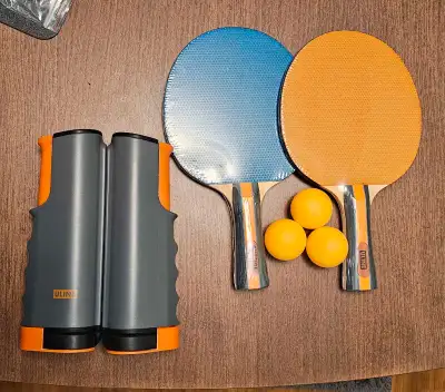 Inside portable table tennis set, complete with two paddles, three balls, and a retractable net, all...