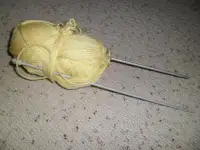 Bundle of yellow yarn with 5mm knitting needles