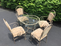 Five piece glass and wrought iron table with four chairs