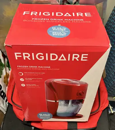 Red Frigidaire frozen drink machine. Makes slushies, margaritas, and more. Uses standard-size ice cu...
