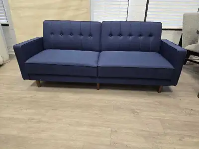 This brand new, modern blue futon sofa bed is perfect for adding style and functionality to any livi...