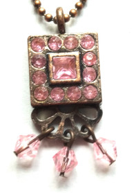 Une chaîne avec pendentif carré de pierres roses