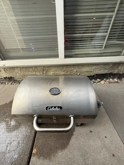 This is a Cabela's portable BBQ in used condition, ideal for camping or small balconies and decks, f...