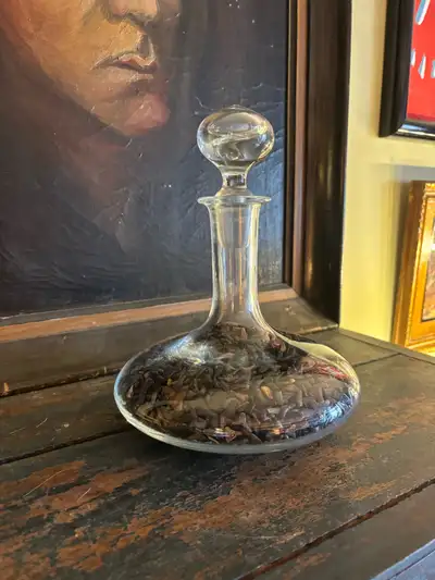 Unique display piece featuring a clear glass bottle filled with a large collection of real shark tee...