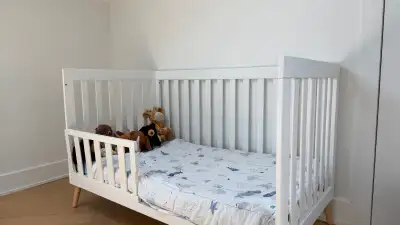 Lit de bébé évolutif Delta Children, modèle Essex, finition Bianca White avec pattes inclinées en pi...