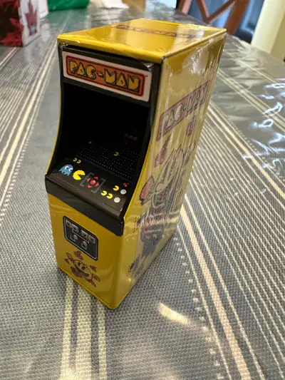 For sale is a new Mini Pac-Man arcade machine candy dispenser tin. The candies are expired now but w...