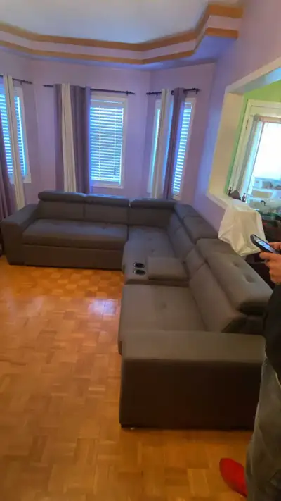 This is a modern grey sectional sofa, perfect for a living room or entertainment area. This used sec...