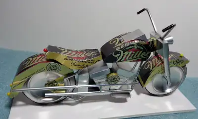 A miniature motorcycle constructed from 51 pieces cut from recycled aluminum beverage cans to produc...