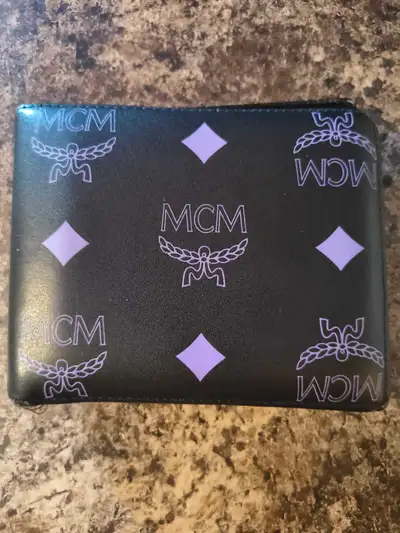 This stylish, used MCM wallet features the brand's signature logo pattern in purple. This wallet is...