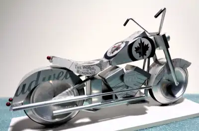 A White-Out miniature Winnipeg Jet motorcycle constructed from recycled aluminum beverage cans. Prid...