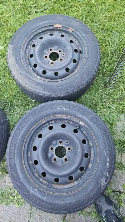 These Bridgestone Blizzak WS60 winter tires are sized 205/65R16 and come mounted on 16-inch steel wh...