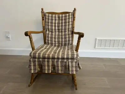 An old-fashioned wooden rocking chair with its original cushions; very comfortable; well-maintained.