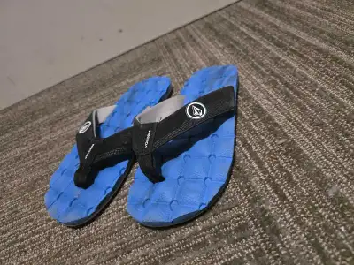 Step into summer with these Volcom flip-flops, featuring a striking blue textured sole and black str...
