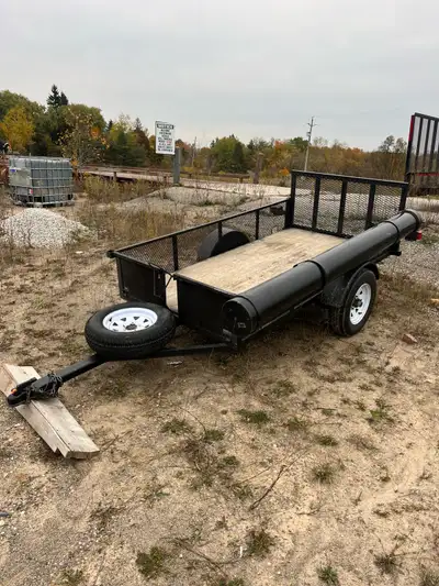 5x8 utility trailer . It features a durable wood floor, a rear mesh ramp for easy loading, the tailg...
