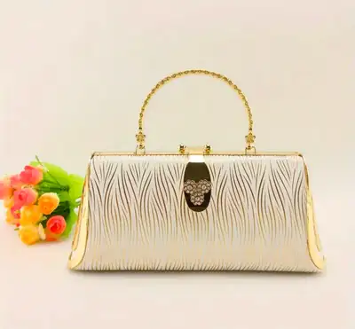 This elegant white and gold clutch is perfect for adding a touch of sophistication to any outfit! Fe...