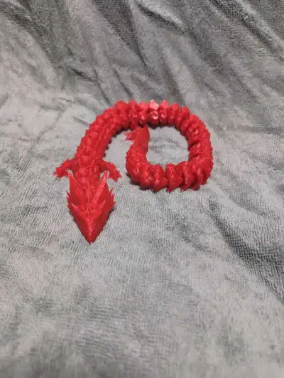 Articulating dragon toy comes in white, black, red, blue, orange, yellow, and multicolor