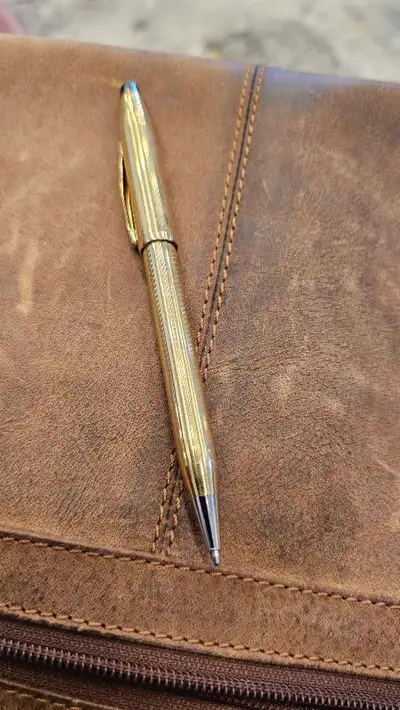 This pre-owned Cross ballpoint pen features a classic, elegant gold-tone finish with fine detailing....