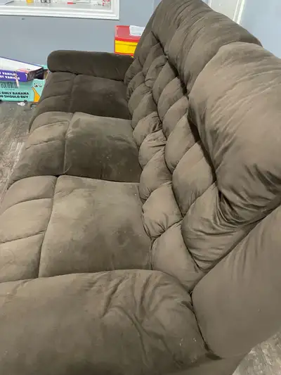 This comfy brown couch features plush, pillowed cushions and is perfect for lounging. Its dimensions...