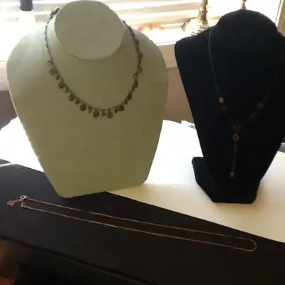 The lot includes three necklaces, two are a brassy color (not sure if they are brass), and the longe...