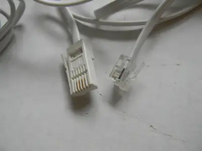 Two telephone cords used in Britain (UK) for connecting a land-line phone to a standard phone compan...