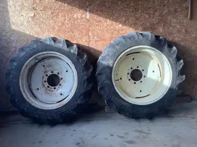 Pair of 9.5-24 8 ply tires on rims. Implement 8 bolt pattern with a 6" porthole. 50% wear.