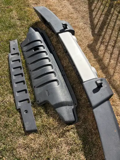 OEM front bumper assembly from a 2015 Jeep Wrangler JK. Includes bumper cover, air dam, and fog ligh...