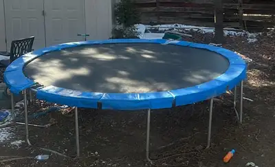 Trampoline 12 pieds sans poteaux avec protection sur les « springs » Petit trou sur la toile environ...