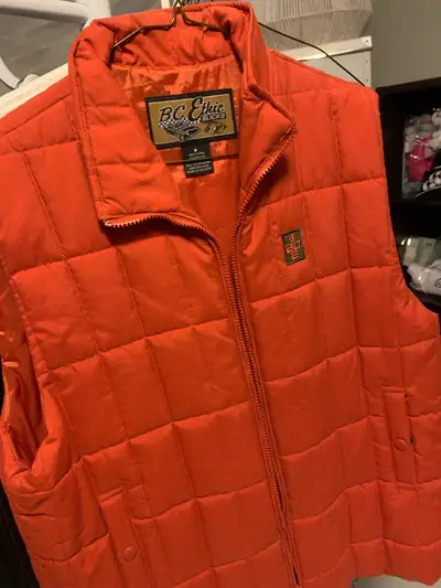 This is a BC Ethic orange vest, size medium. It's a great piece for adding a pop of colour and warmt...