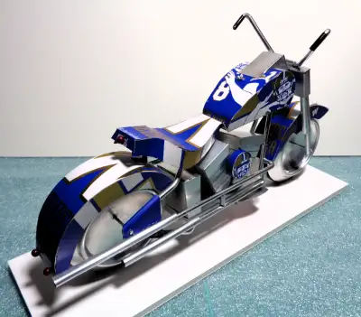 A miniature motorcycle constructed from 51 pieces cut from recycled aluminum cans of a favorite beve...