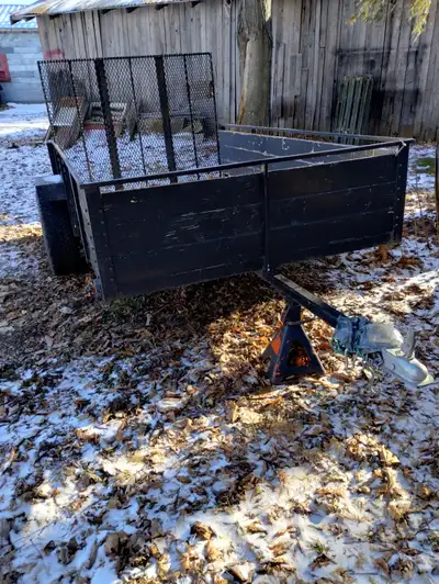 Remorque utilitaire ouverte de type standard, probablement autour de 4x8 à 5x10 pieds, avec une ramp...