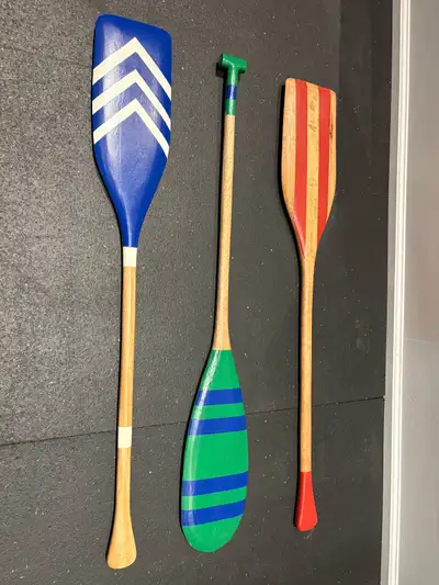Add a touch of nautical charm to your space with these decorative canoe paddles. This set of three p...