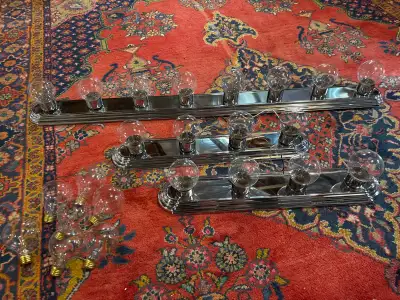These three pre-owned chrome vanity light bars offer a classic Hollywood-style aesthetic perfect for...