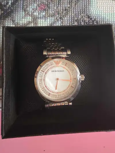 This is a pre-owned Emporio Armani watch with a crystal embellished face and two-tone band. It is in...