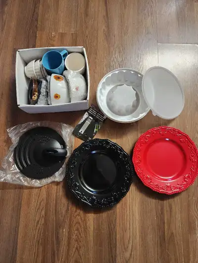 This is a mixed lot of kitchen and dining items. Included are mugs, bowls, Tupperware molds, and Mar...