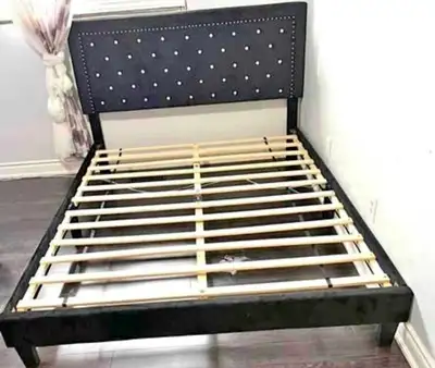 This is a queen-sized bed frame featuring a sleek, black velvet headboard adorned with button-tufted...