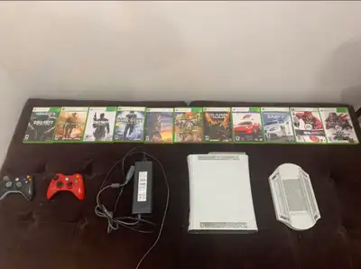 Xbox 360 for sale with 11 games, 2 controllers and colling stand, View more