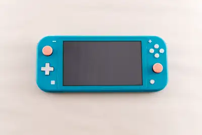 Turquoise Nintendo Switch Lite comes with charger and ergonomic grip. Comes loaded with a bunch of g...