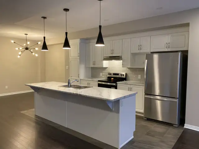 Like-new 2300 sq ft end unit townhouse backs onto pond.